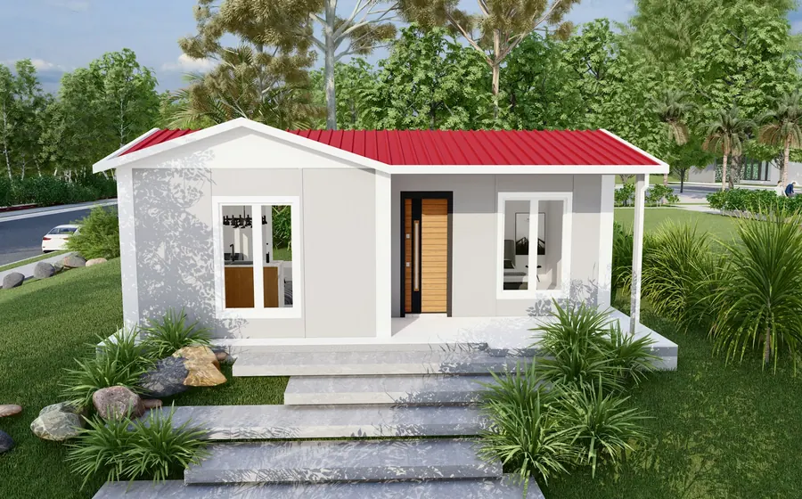 Casa prefabricada pequeña de techo rojo sobre una base nivelada en un jardín